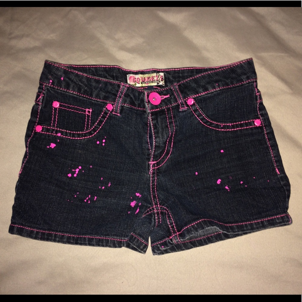 Black jean shorts with pink paint splatters